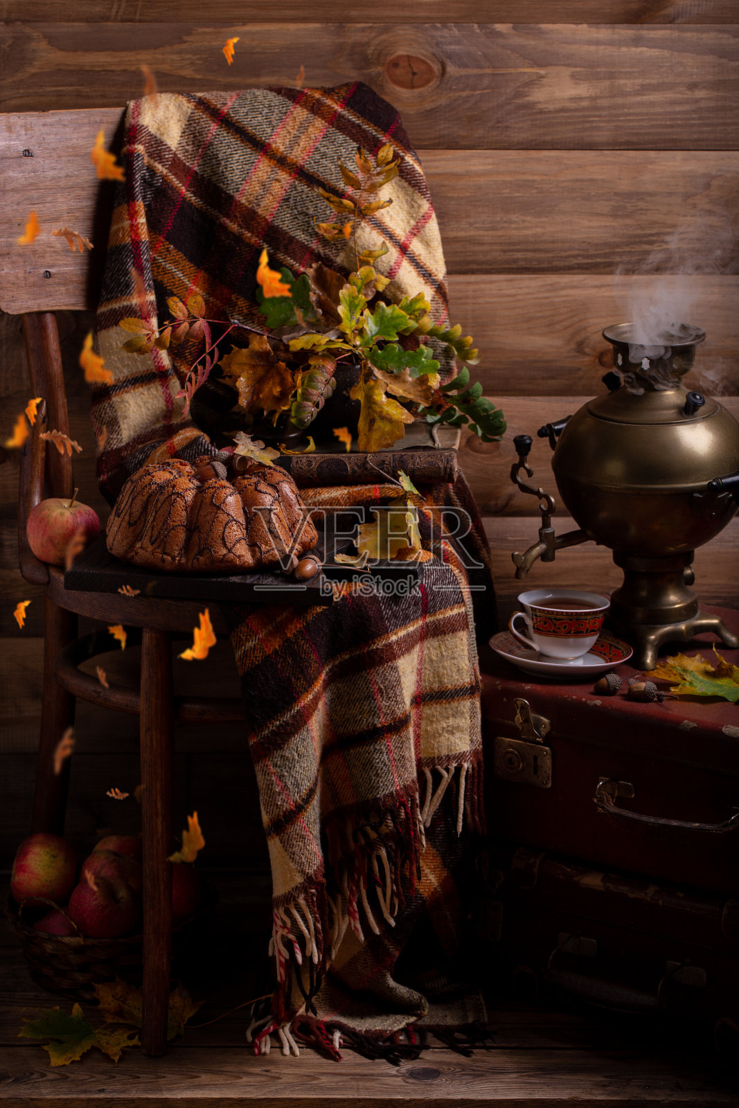 一块巧克力松饼，格子呢上有茶壶。照片摄影图片