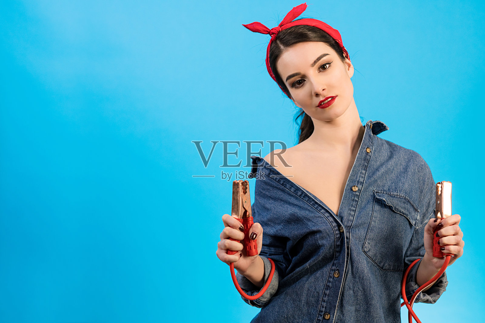 蓝色背景上那个开心的女人拿着跨接线照片摄影图片
