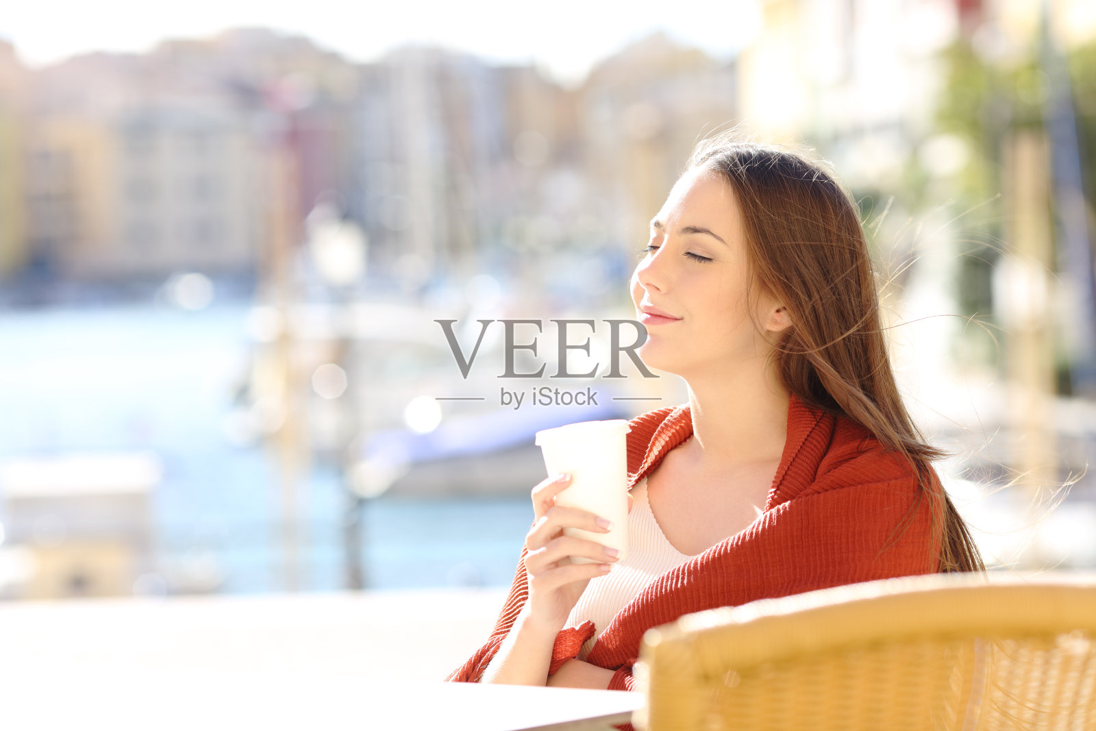 一个女人在咖啡店里拿着饮料放松照片摄影图片