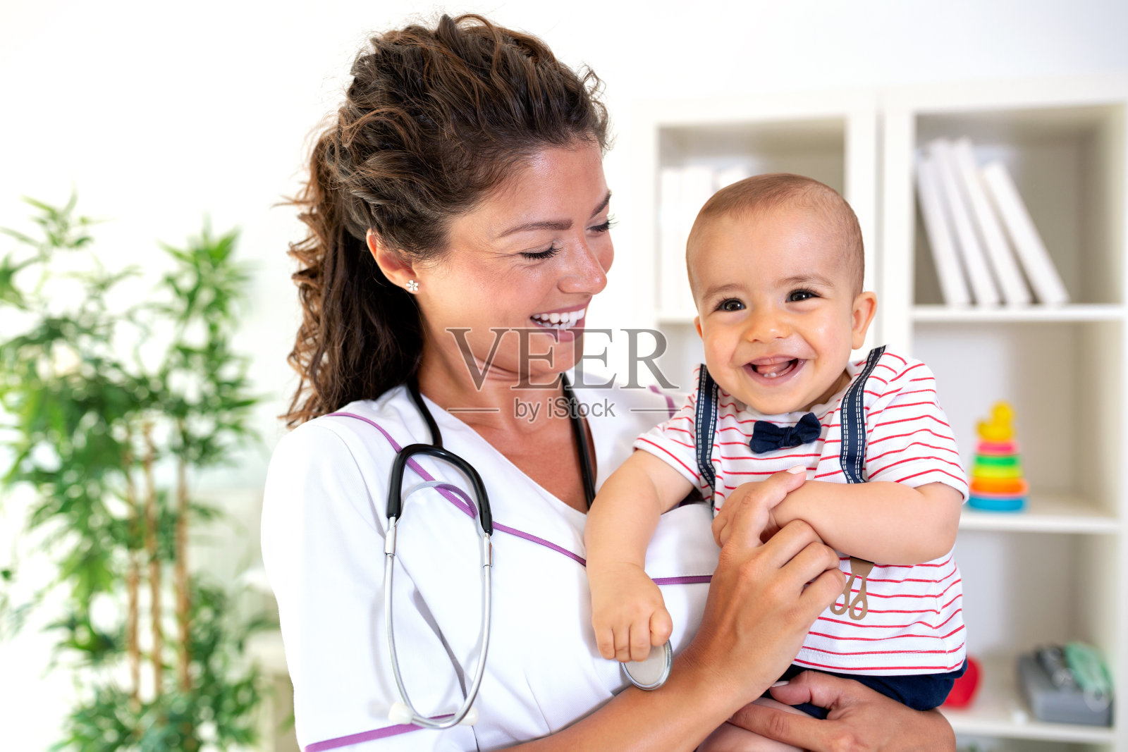 宝宝好奇地看着，医生用赞许的目光回头看照片摄影图片