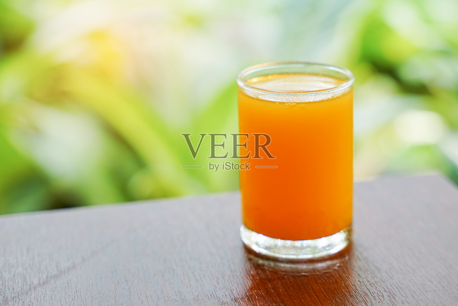 冷橙汁在玻璃在软焦点桌子模糊的背景照片摄影图片