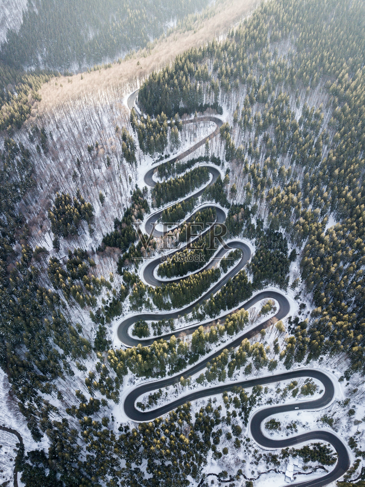 弯弯曲曲的山路，在冬天的时候。无人机鸟瞰图。罗马尼亚照片摄影图片