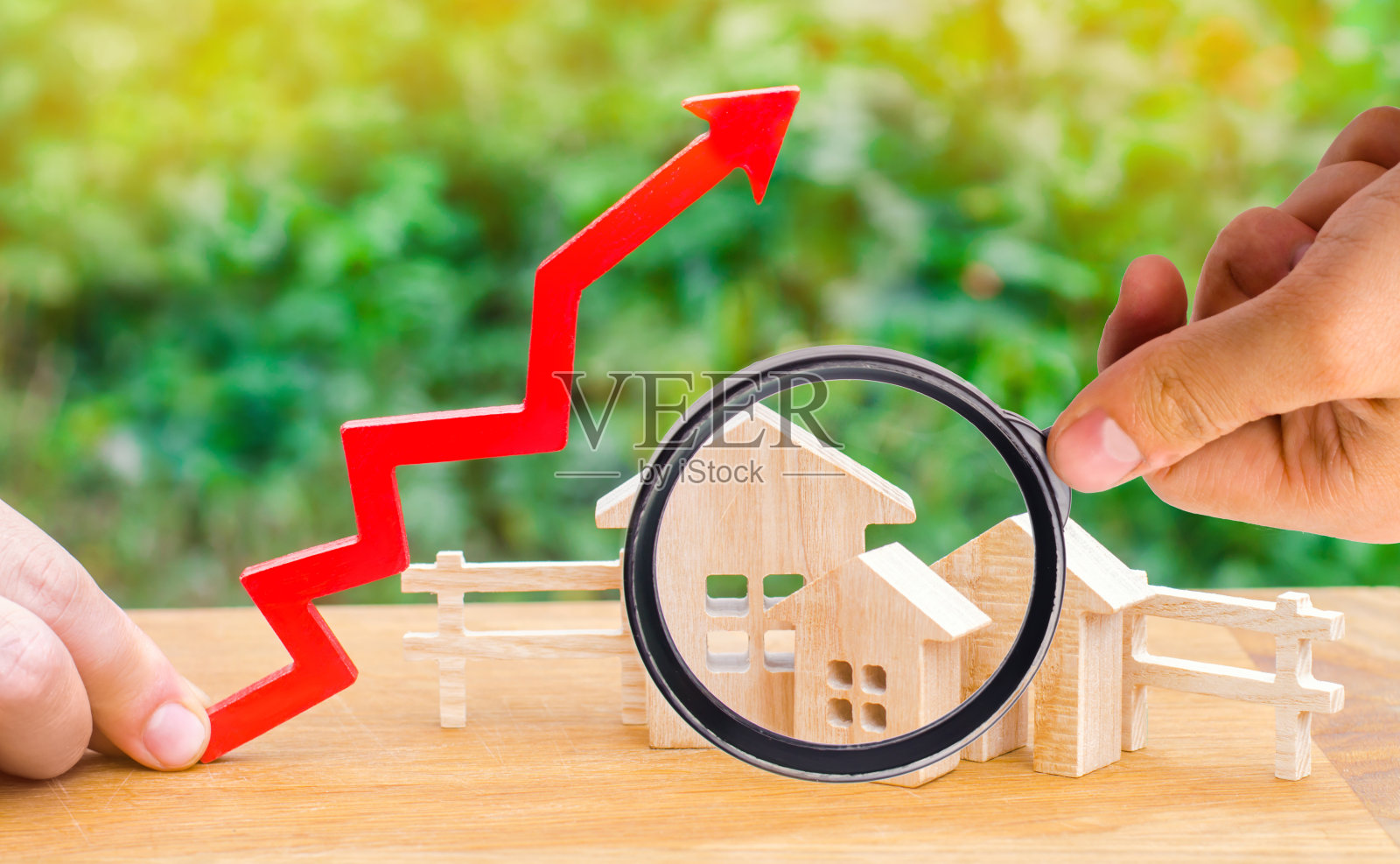 上面有红色箭头的木屋。房地产高需求的概念。房价上涨。人口增长。公用事业成本增加。财产。房地产经纪人的服务照片摄影图片