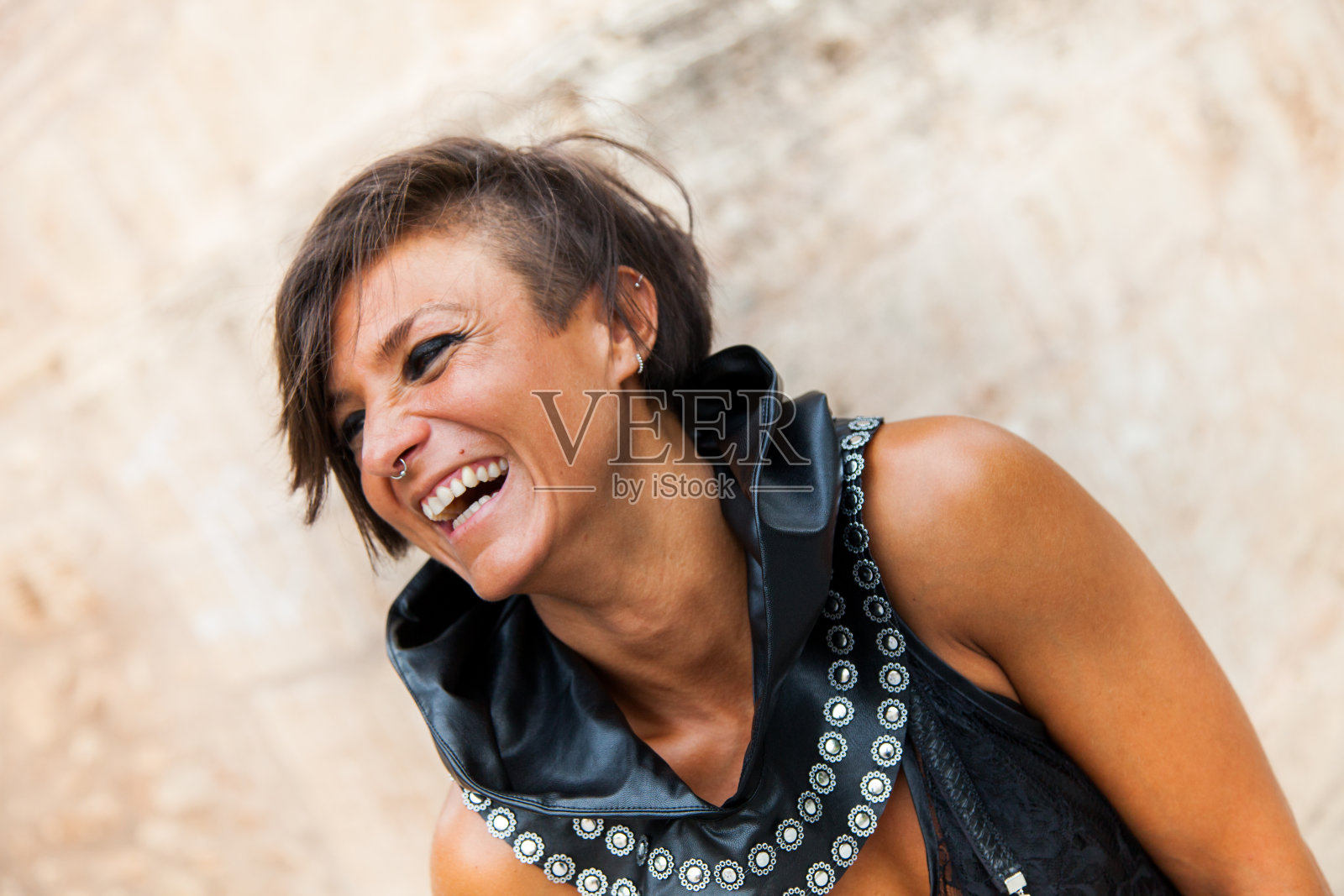 一个微笑的黑发女人的肖像与浅色眼睛和中世纪风格的皮革服装照片摄影图片