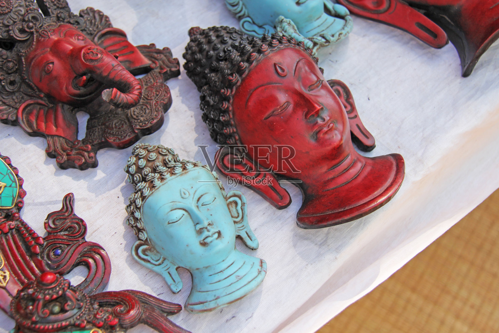 在印度的集市上，佛陀的红脸是蓝色的甘尼萨。佛像和甘尼萨。印度礼物纪念品照片摄影图片