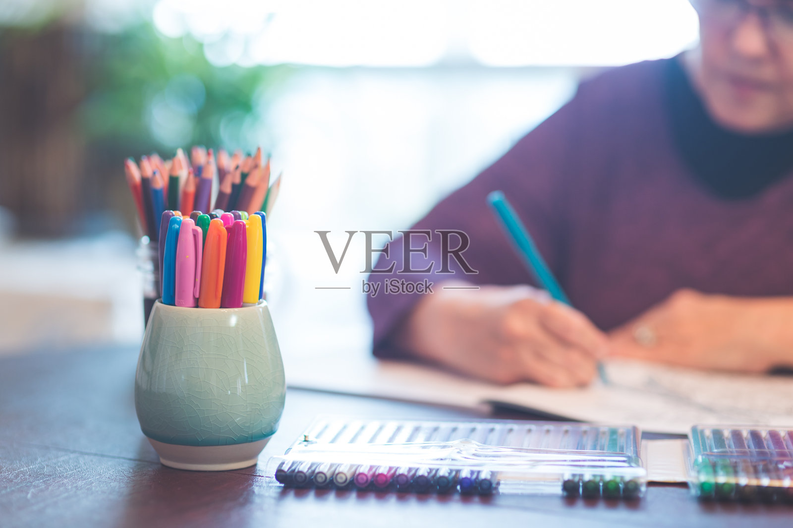 年长的女人在涂色本上画画照片摄影图片