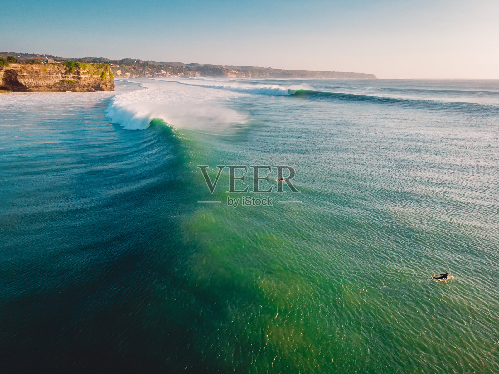 海洋中完美的巨浪鸟瞰图。巴厘岛最大的海浪和冲浪者照片摄影图片