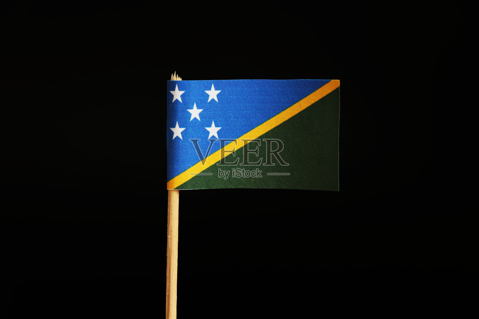 这是一面美丽的蓝绿相间的所罗门群岛旗帜，旗帜用木棒插在黑色的背景上。所罗门群岛属于大洋洲照片摄影图片