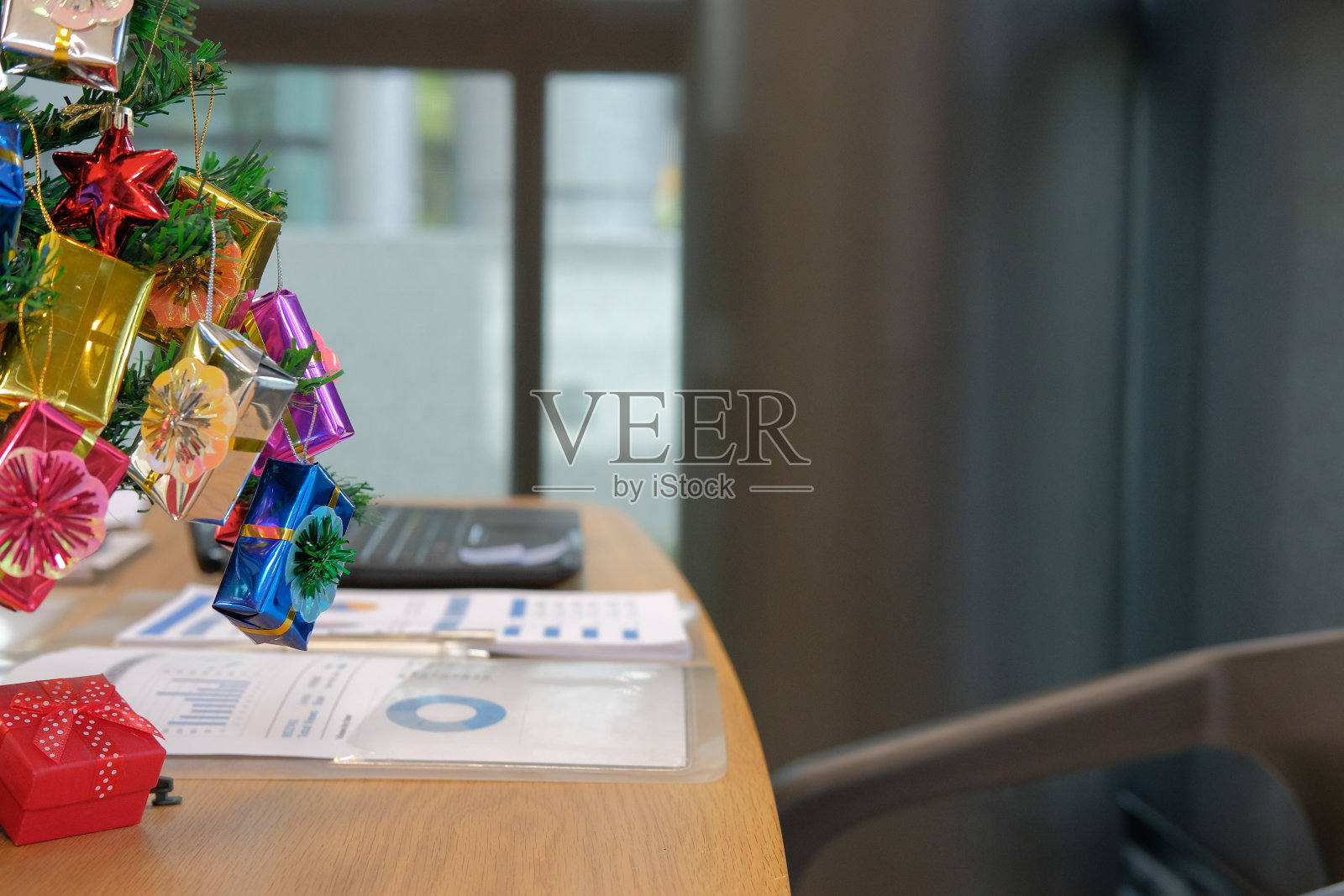 装饰过的圣诞树文件电脑放在办公桌上照片摄影图片
