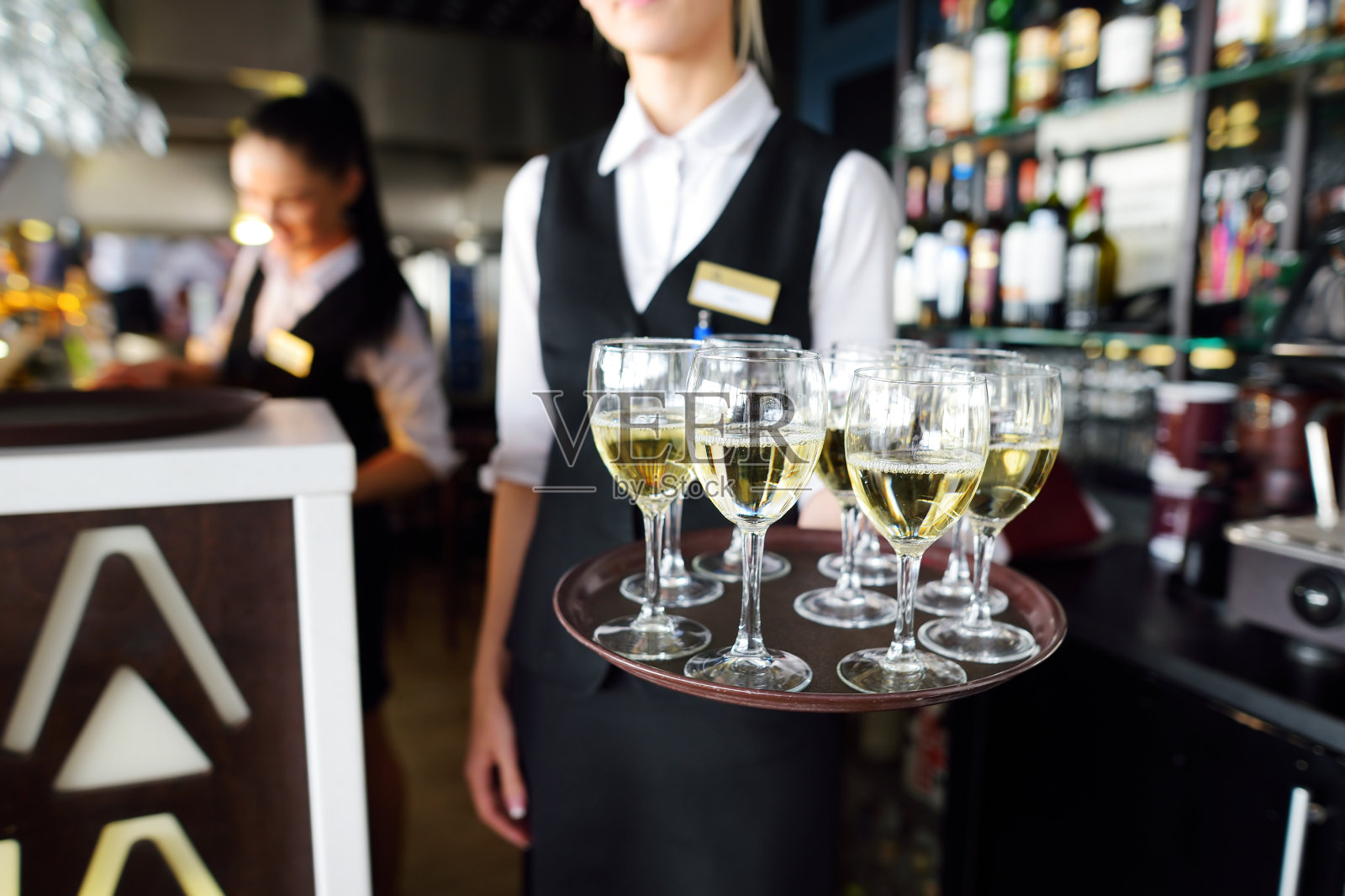 侍者端着一盘香槟和酒杯照片摄影图片