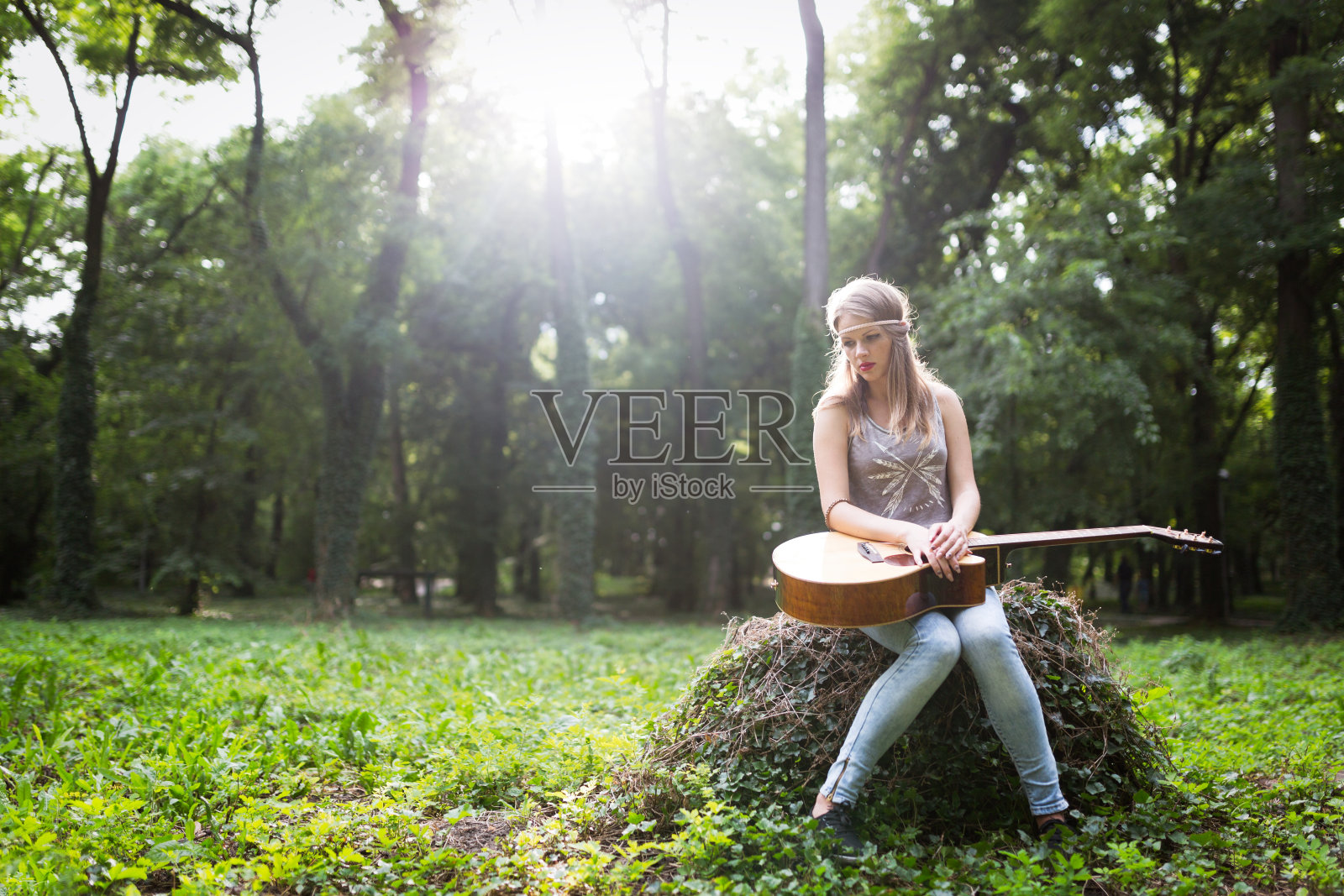 在户外弹吉他的伤心女人照片摄影图片