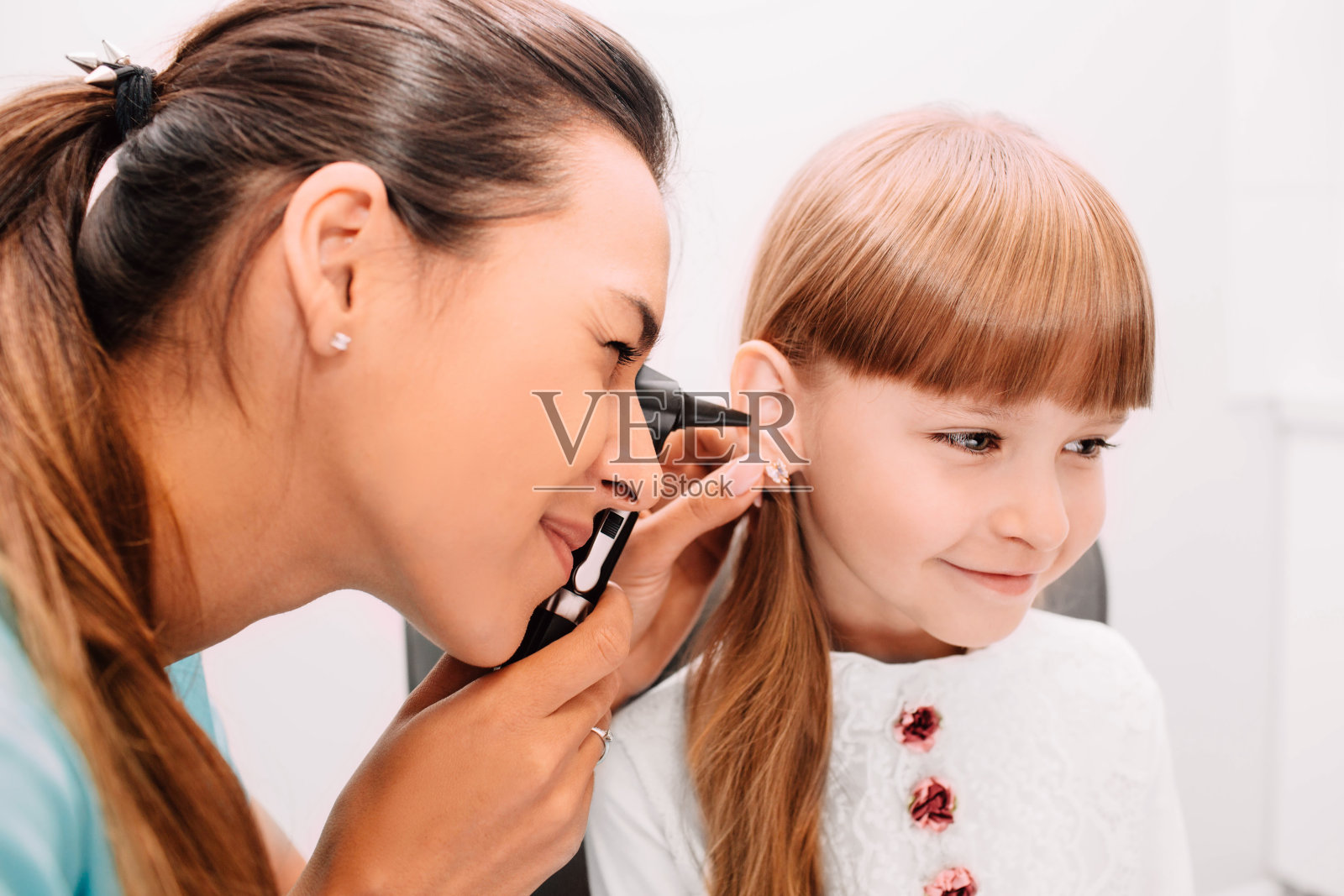 微笑医生使用耳镜检查儿童耳朵照片摄影图片