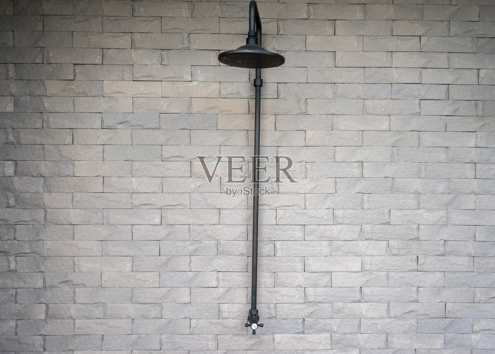 游泳池附近的室外淋浴，灰色墙壁由加气混凝土砌块制成。照片摄影图片