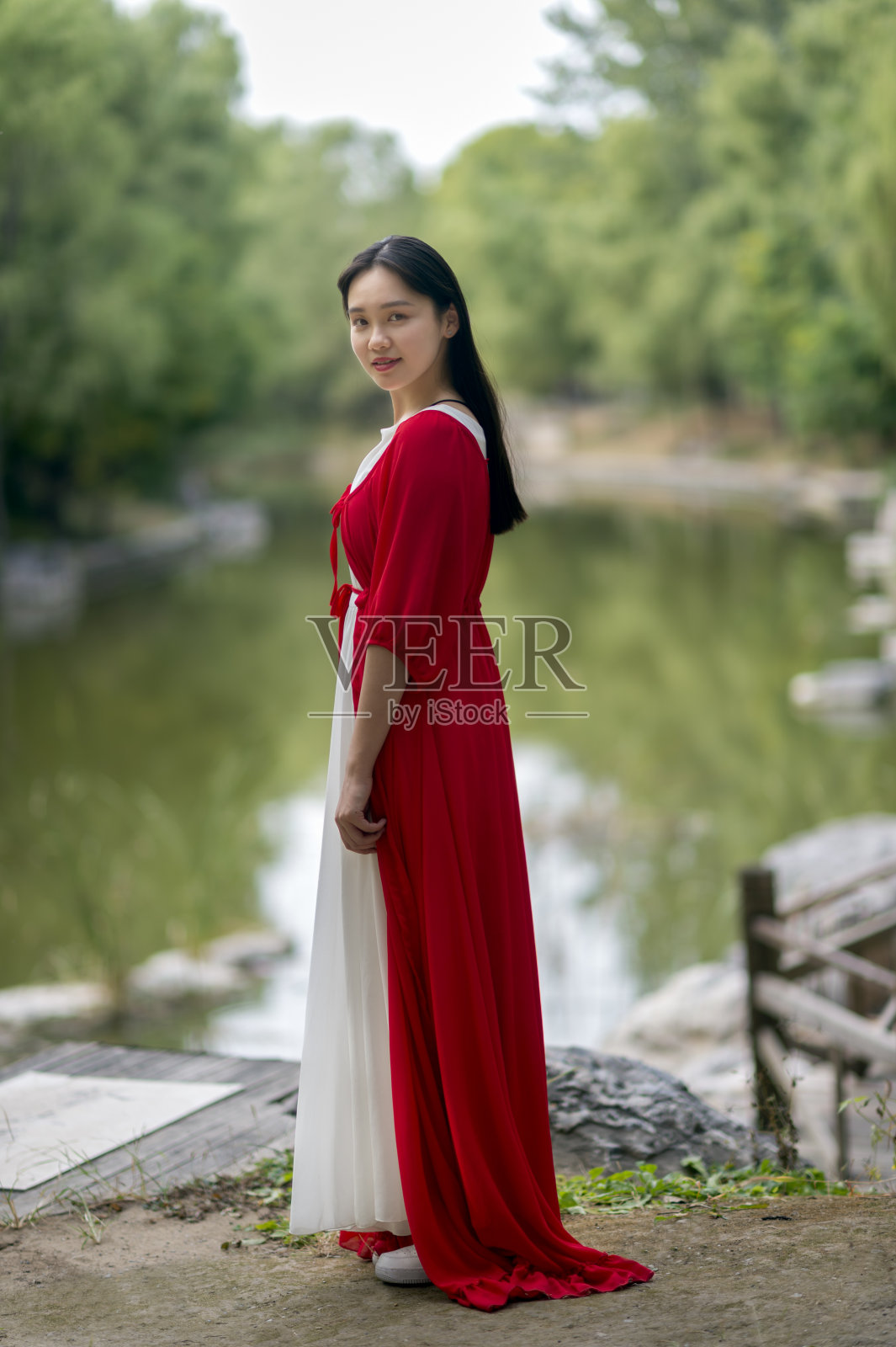 一个穿红衣服的女孩在公园散步照片摄影图片