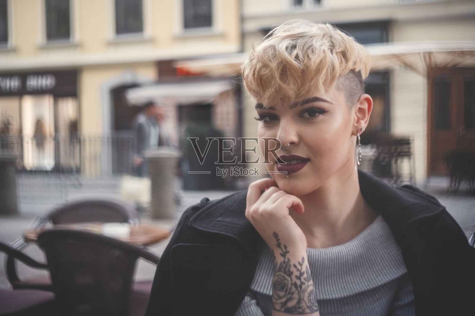 年轻女子坐在户外咖啡馆里照片摄影图片