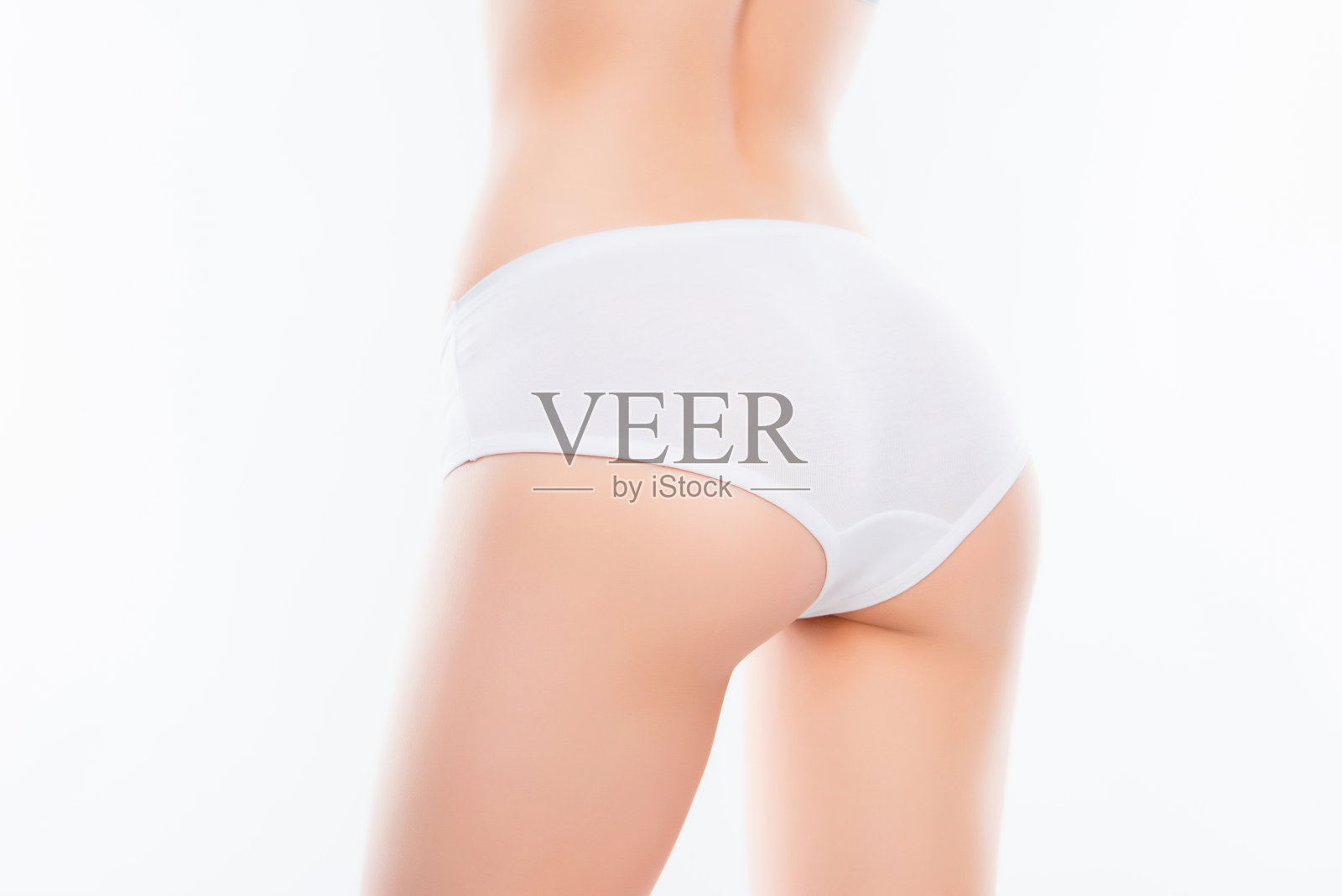 近距离的照片，适合女人的臀部与完美的理想皮肤在白色内衣隔离在白色背景的结果反脂肪团霜磨砂。健康健康水疗沙龙概念照片摄影图片