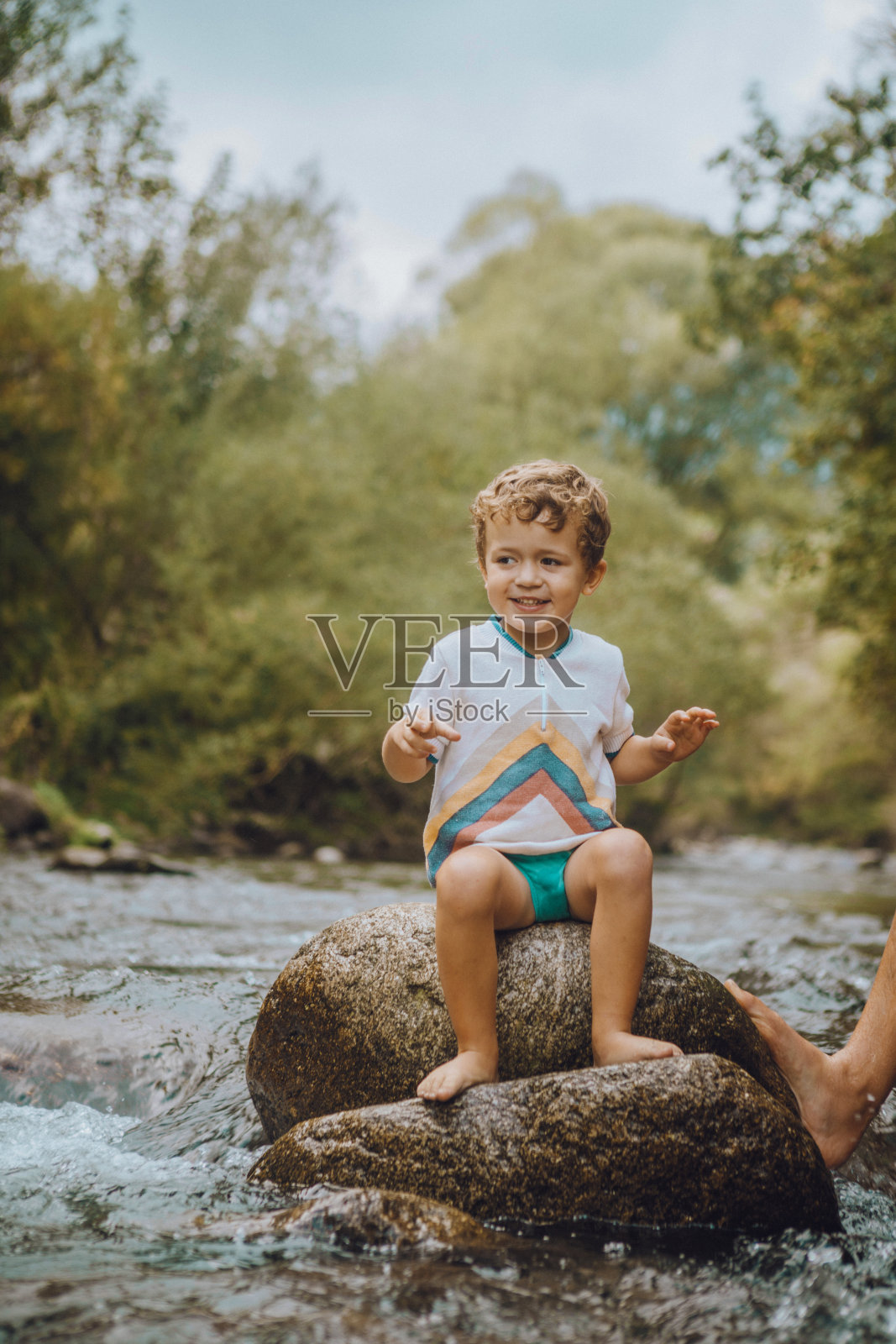男孩和他的父亲在河里玩照片摄影图片