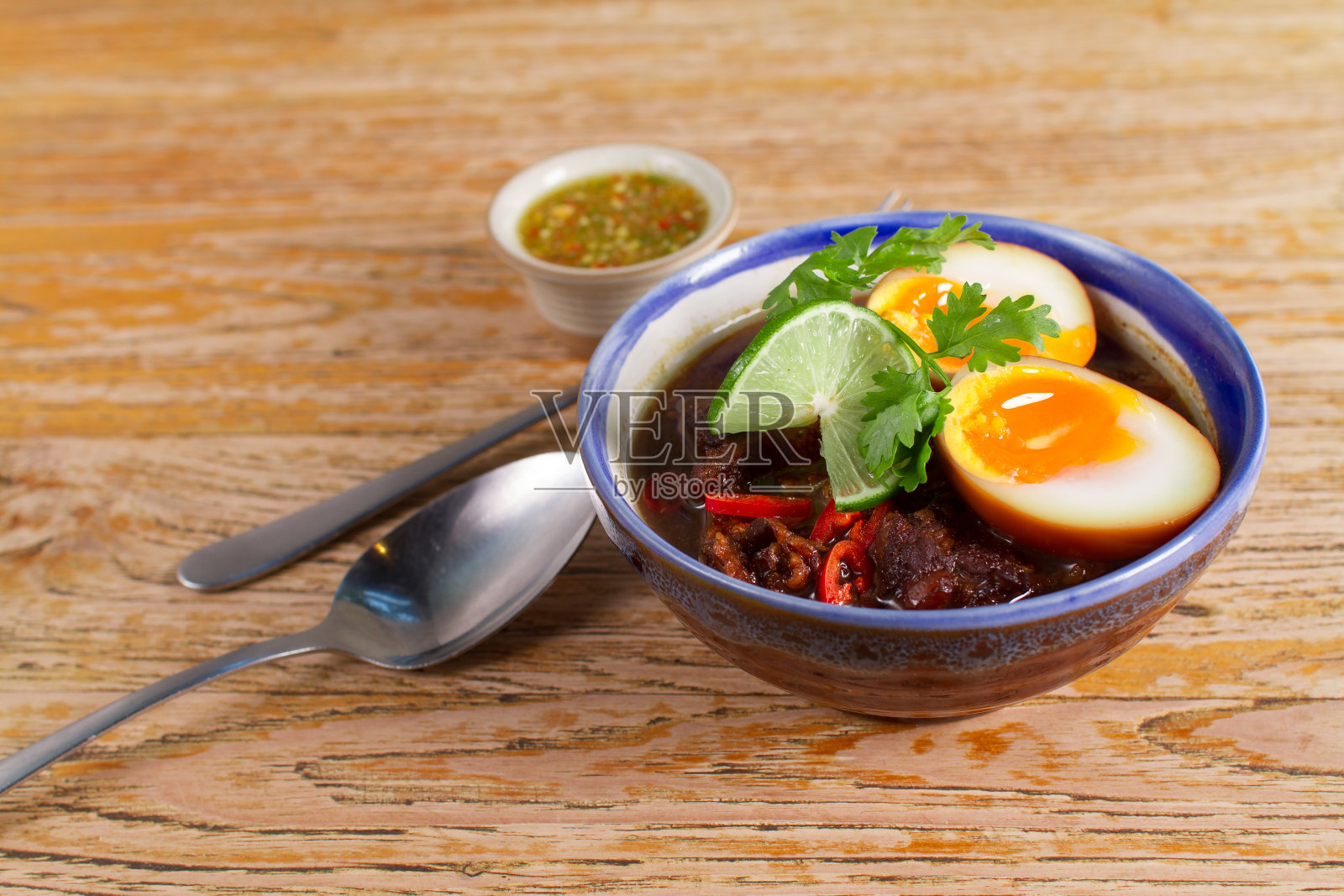 亚洲食物，甜棕酱猪肉和鸡蛋，猪肉和鸡蛋炖在肉汁和泰国辣酱在木背景照片摄影图片