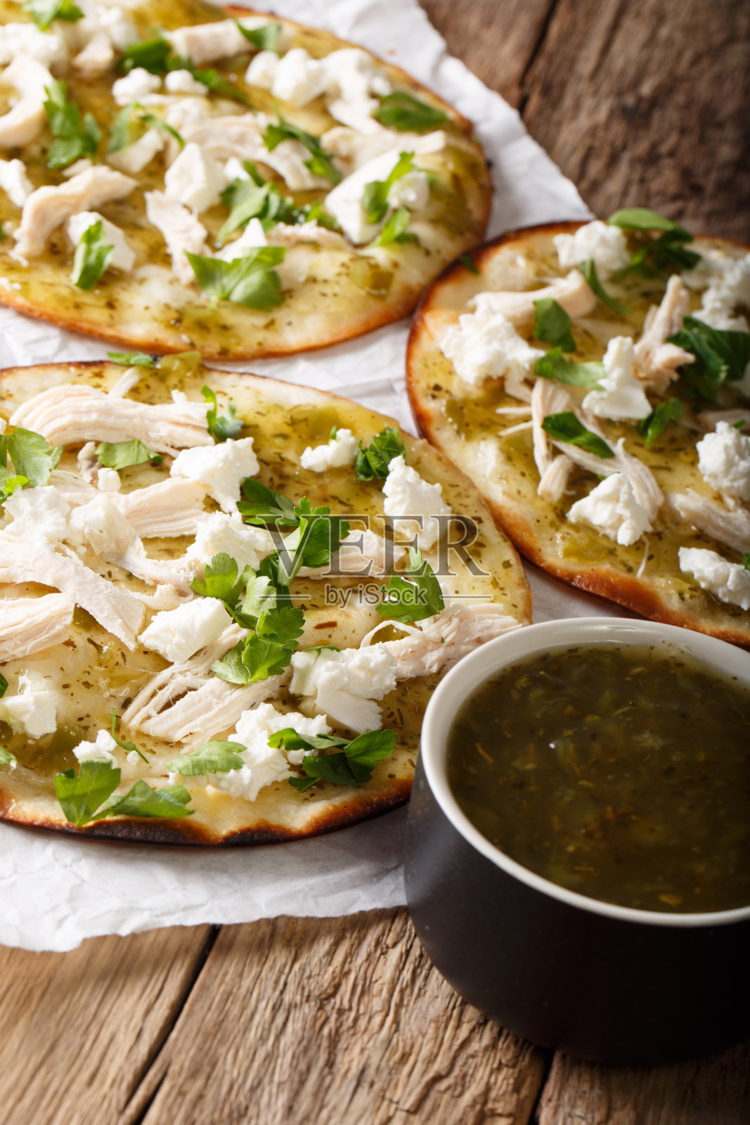 墨西哥快餐墨西哥卷饼与新鲜的奶酪和鸡肉和绿色酱近距离。垂直照片摄影图片