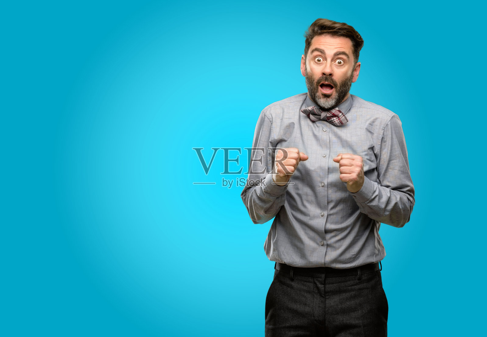 中年男子，留着胡子，打着领结，高兴又惊讶地欢呼着，表示惊讶照片摄影图片