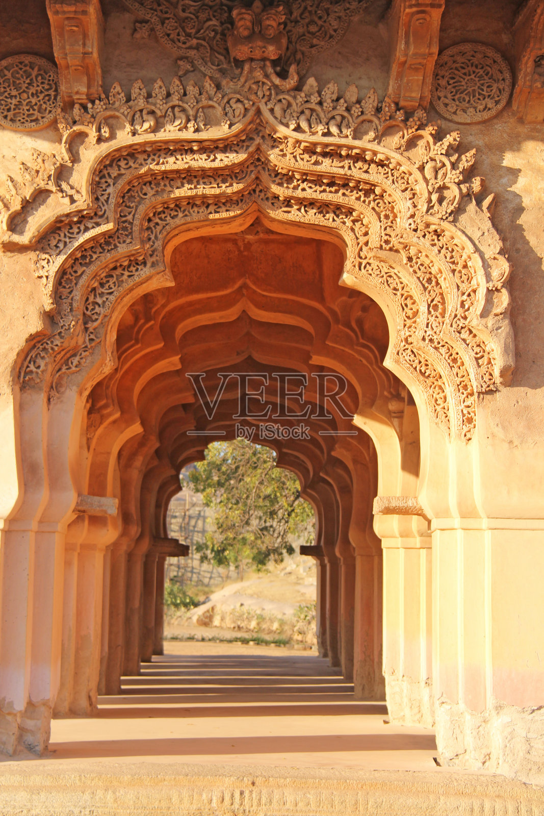 印度卡纳塔克邦汉比的莲花玛哈庙。美丽的石雕拱门和夕阳。这是一条从果阿州出发的热门旅游线路。美丽的印度寺庙照片摄影图片
