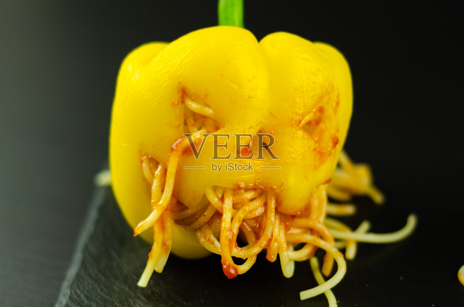 彩色填充辣椒配上吓人的鬼脸，万圣节派对食物照片摄影图片