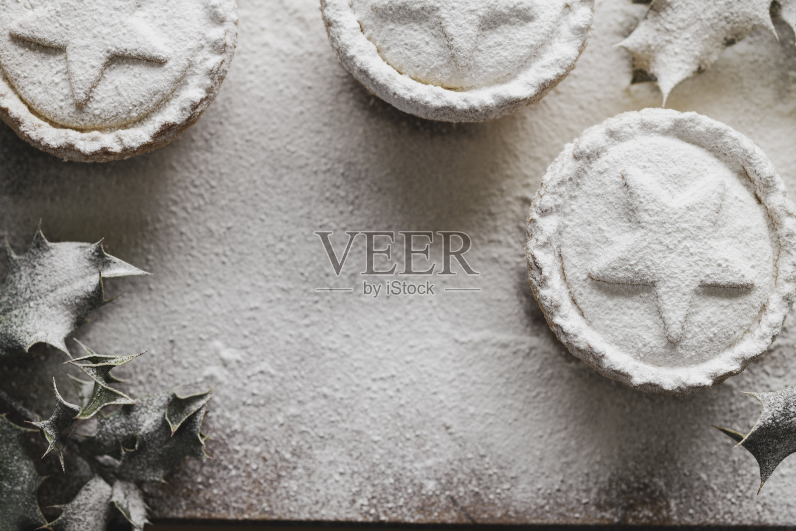 碎肉派撒上糖霜，冬青-圣诞食品。照片摄影图片