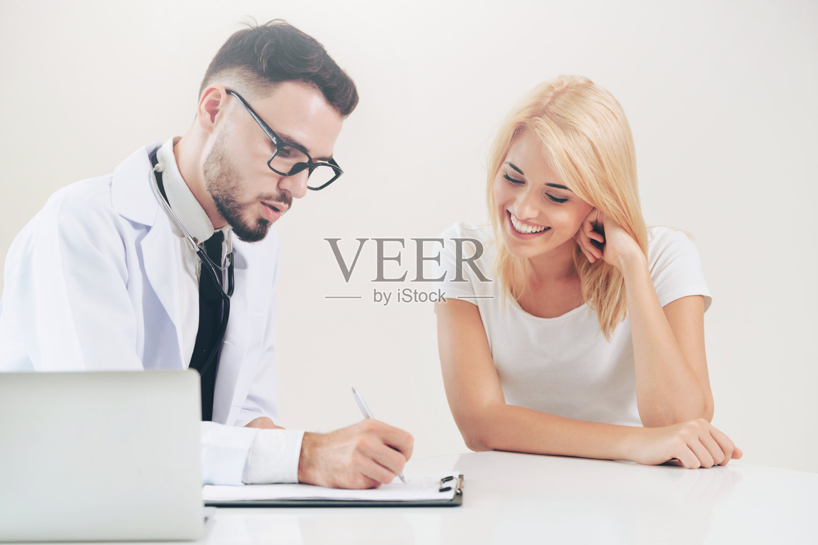 医院办公室的男医生和女病人照片摄影图片