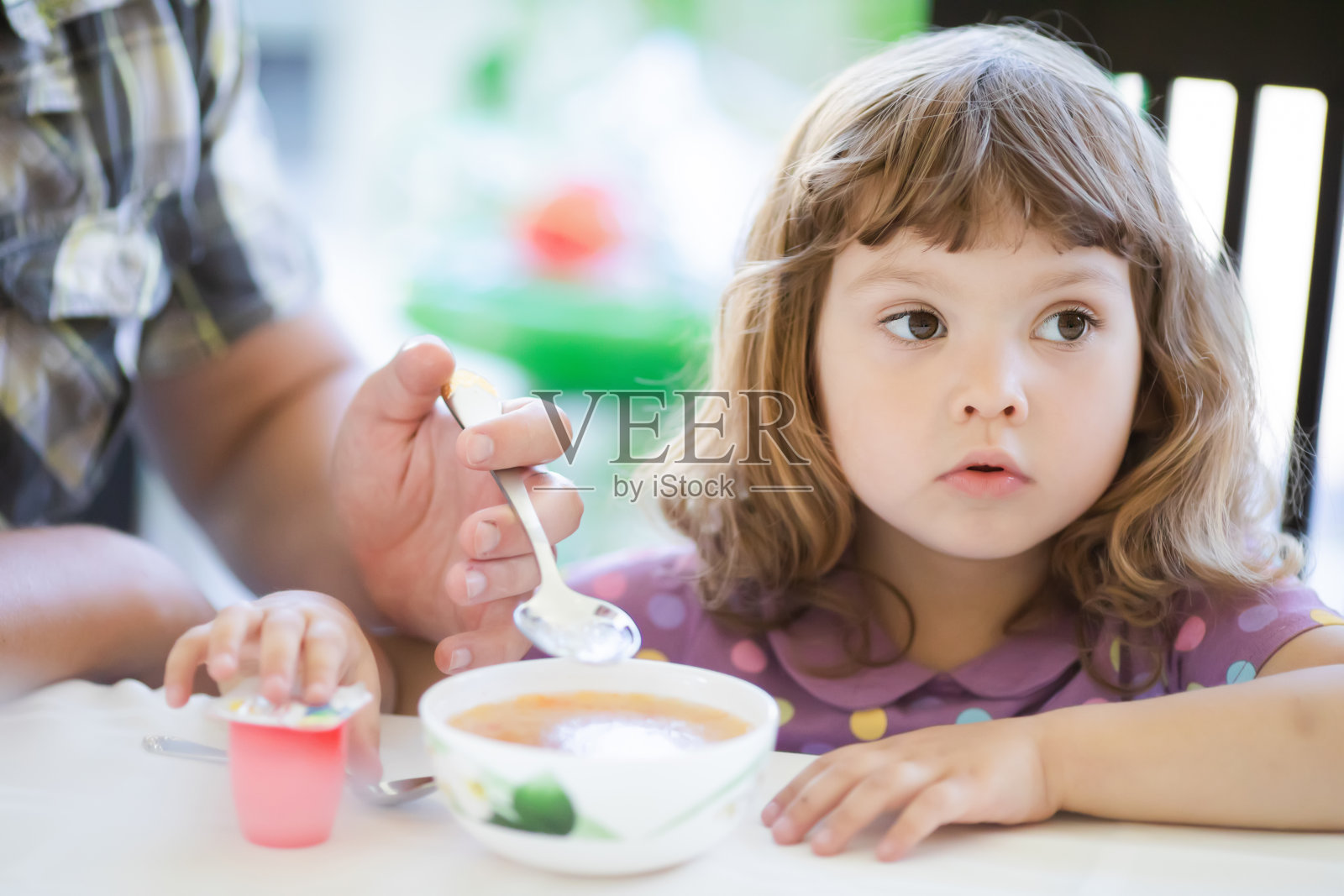 年轻的父亲喂养他的小女儿，父亲的身份照片摄影图片