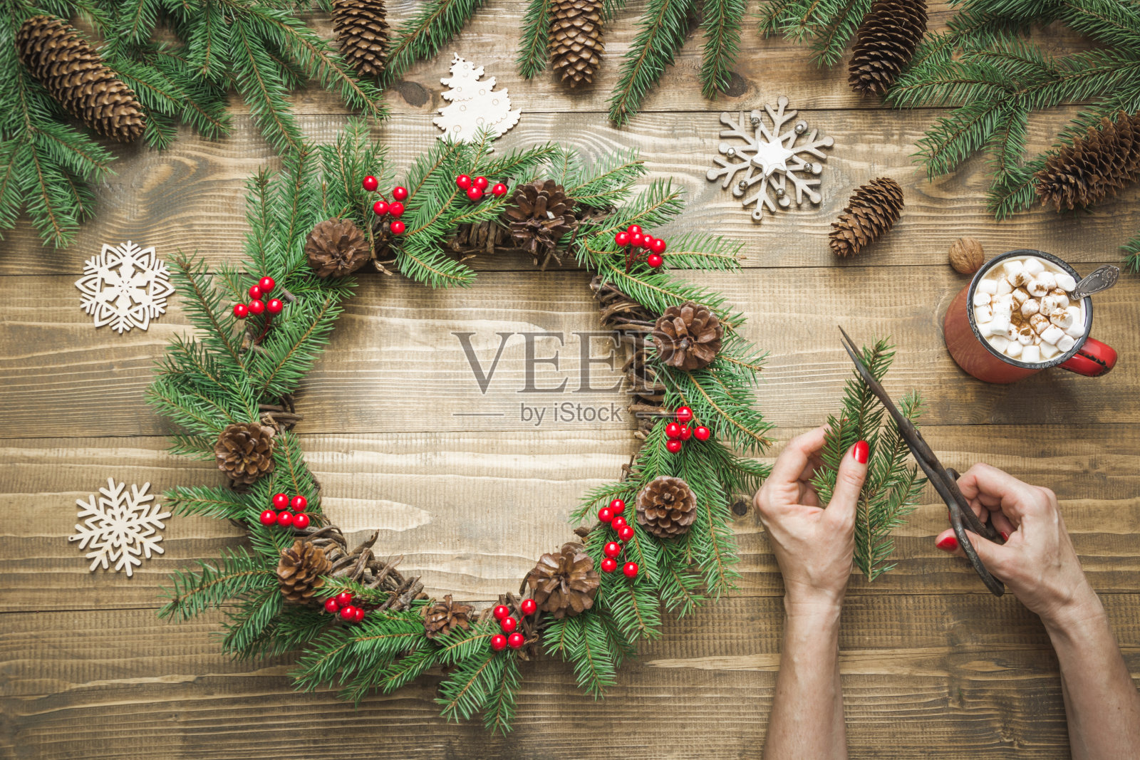 用新鲜的天然材料制作圣诞花环的女人。车间。圣诞节。车间。照片摄影图片