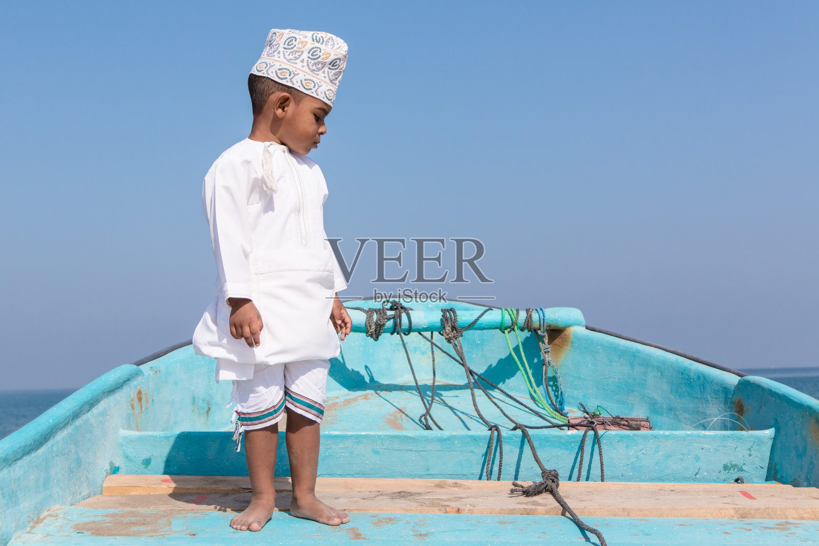 在海滩边玩耍的阿曼男孩照片摄影图片