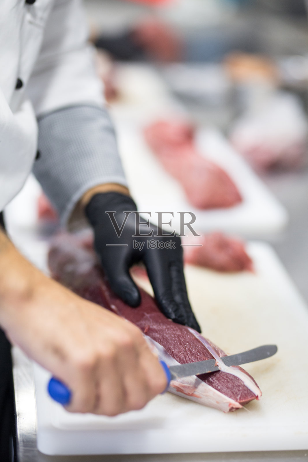 厨师从肉中去除坏的部分照片摄影图片