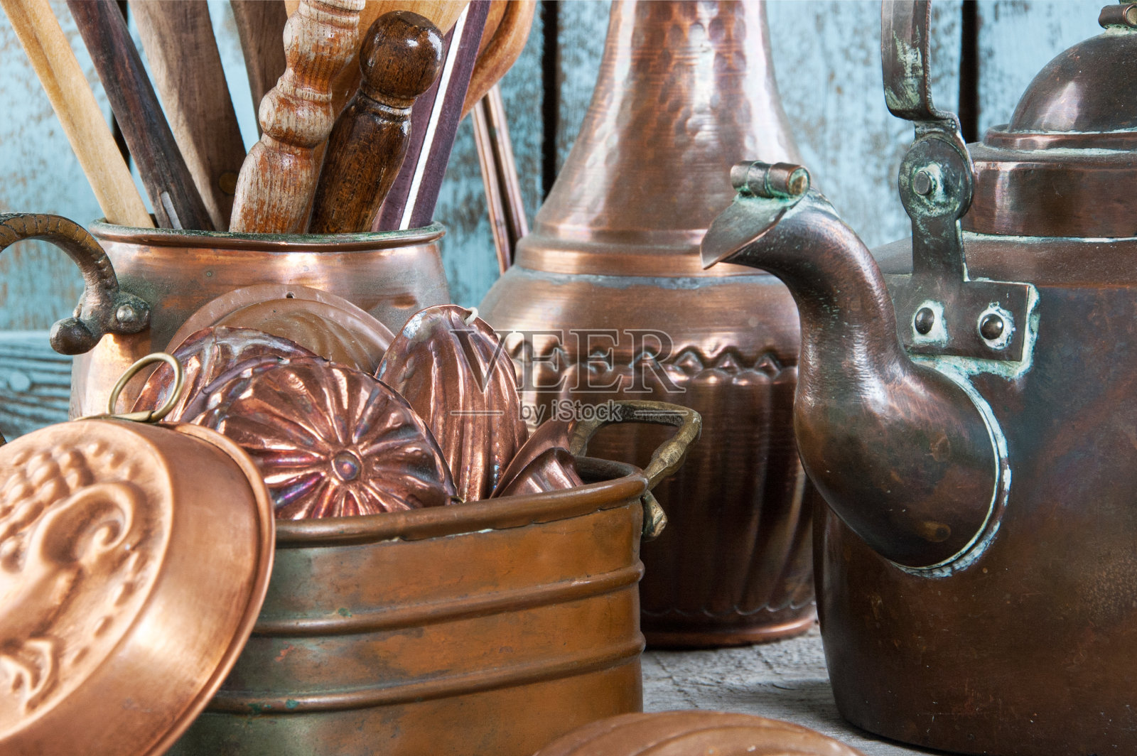 木制蓝色背景上的老式铜厨房用具。照片摄影图片