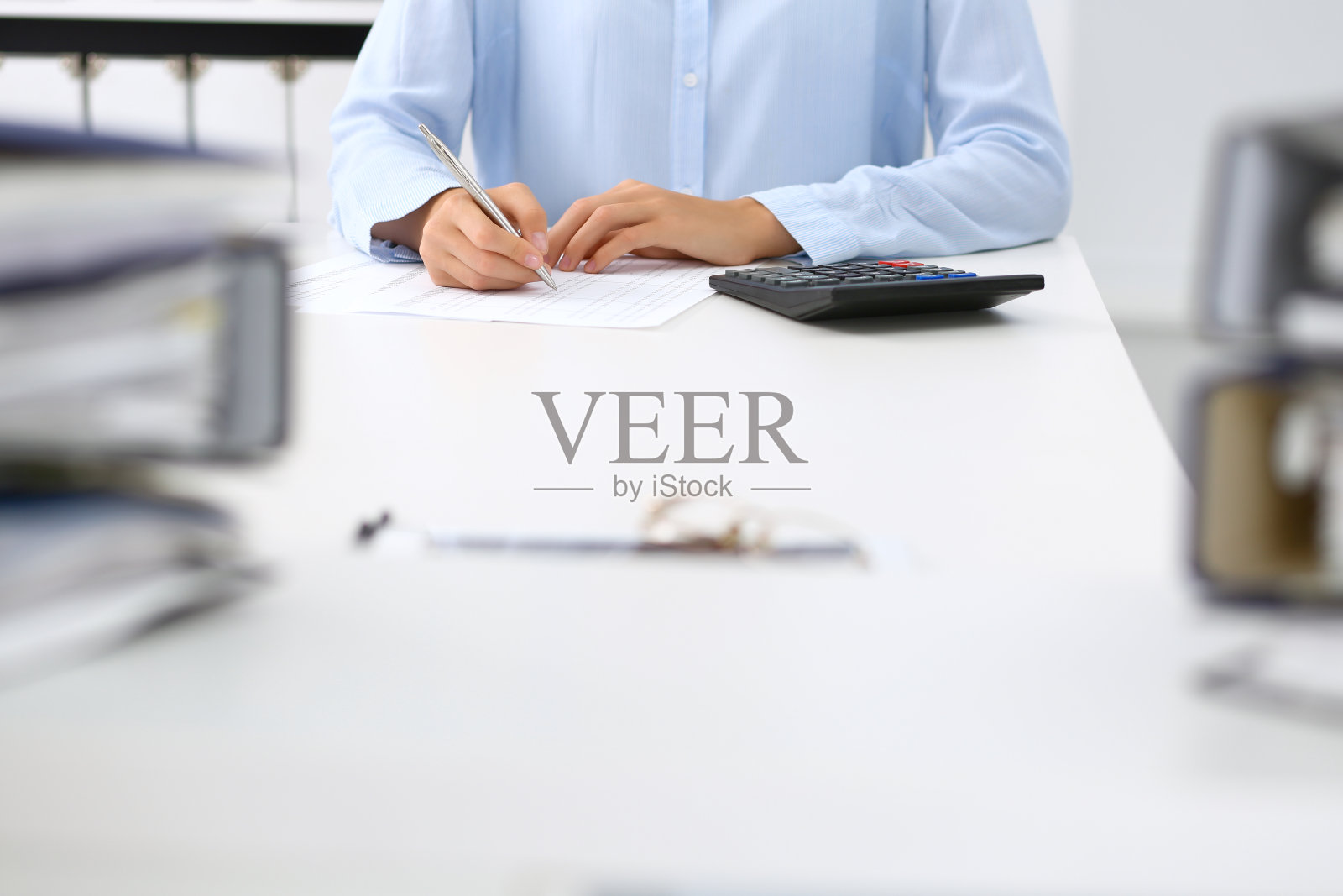 未知女簿记员或财务检验员计算或检查余额，报告，特写。国内税务局负责处理财务文件。税务和审计概念。照片摄影图片