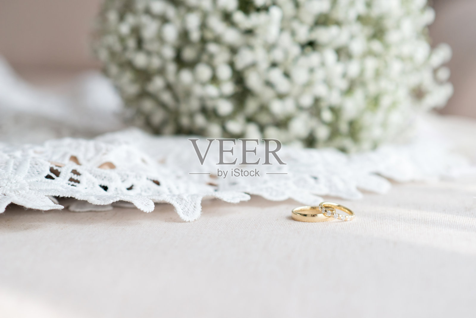 结婚戒指和新娘花束白色蕾丝婚纱-选择焦点，复制空间照片摄影图片