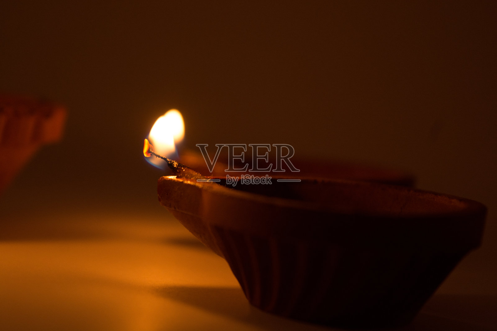 在黑暗的背景上的排灯节terracotta diyas的特写，这是在排灯节期间用来照亮房子。照片摄影图片