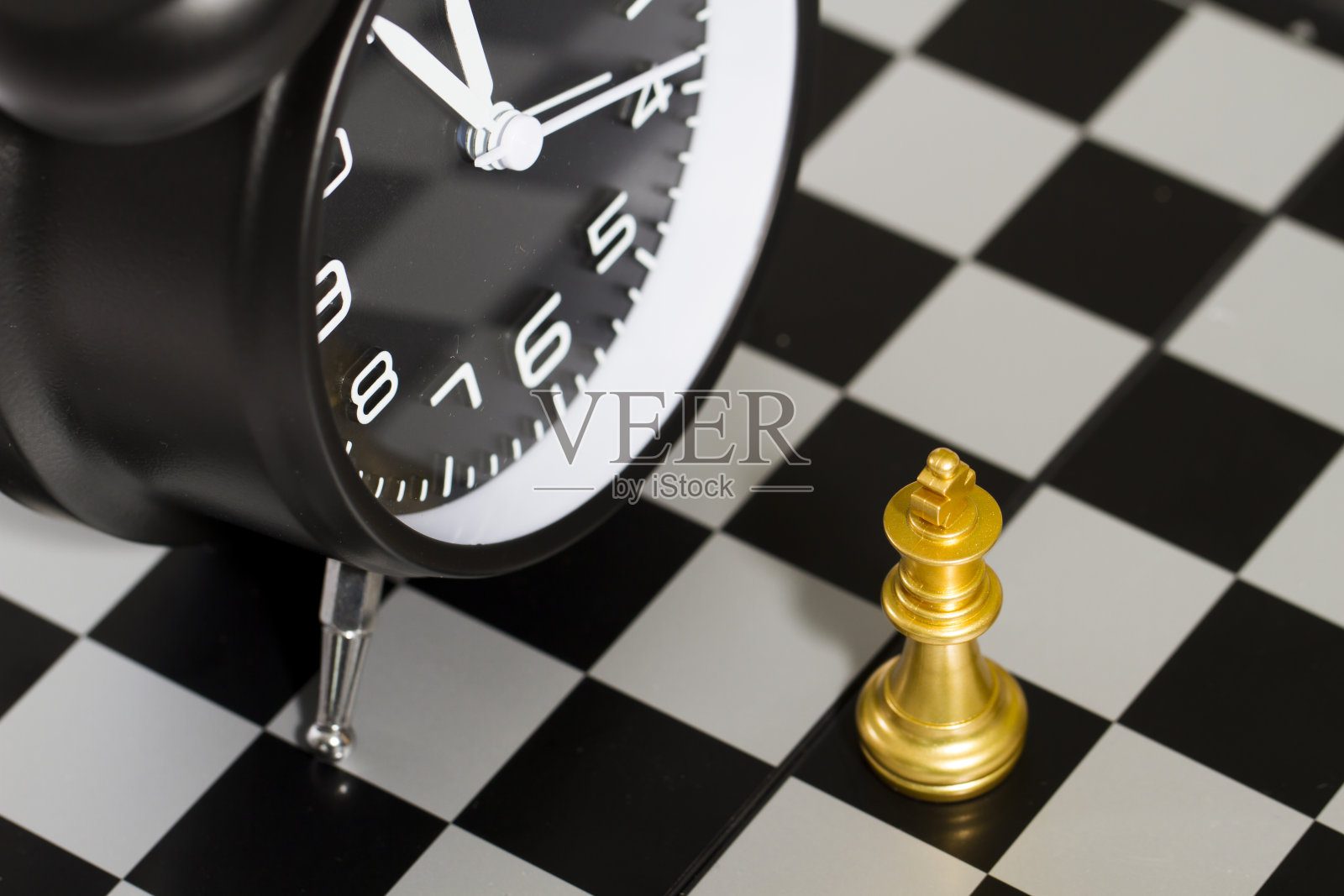 时钟和棋子，代表着时间的重要性，为时间而战照片摄影图片