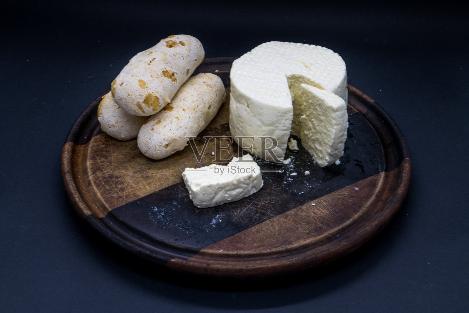 奶酪面包和巴西米纳斯白奶酪在木砧板上孤立在黑暗的背景照片摄影图片