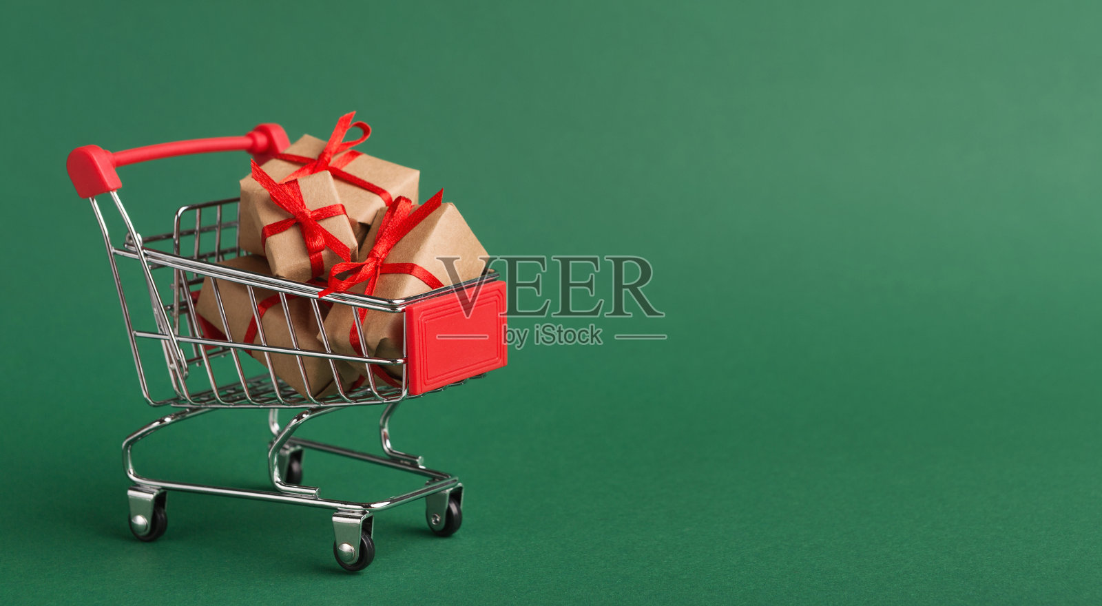 购物车与工艺圣诞礼物在绿色的背景照片摄影图片