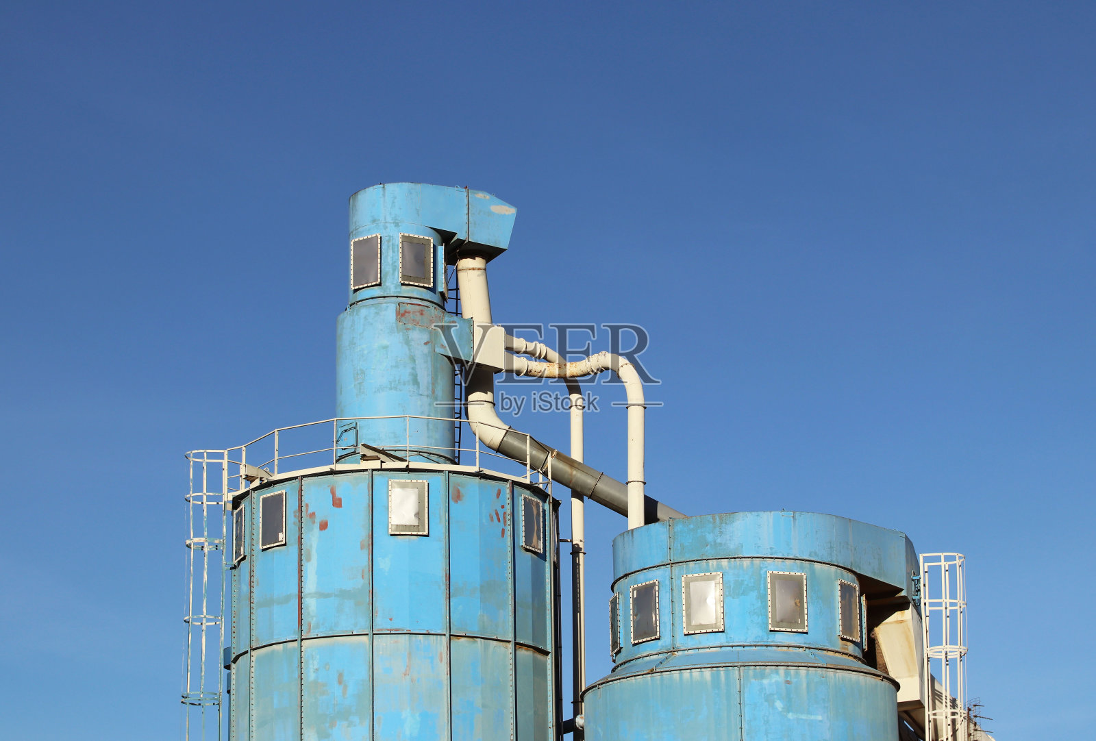 木材加工车间通风系统。金属结构的空气流通，在一个晴朗的日子里，在一个蓝天木工工厂。企业的安全和工作条件照片摄影图片