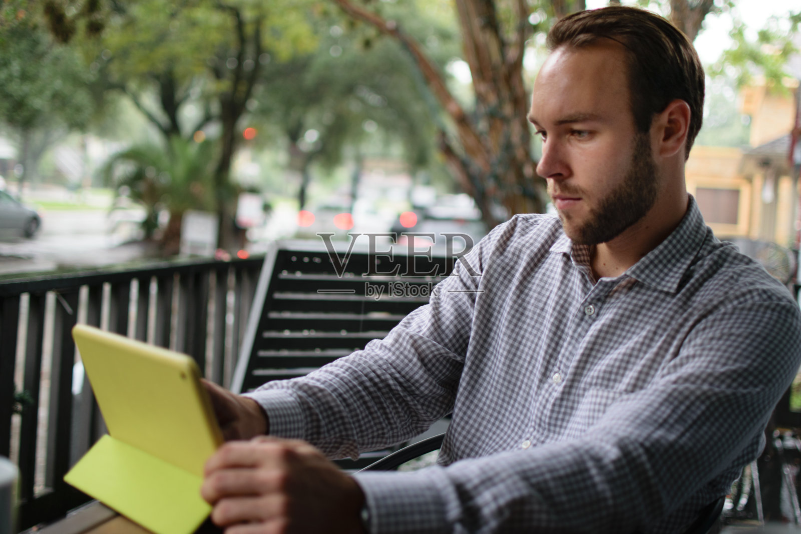 一名男子在户外咖啡店使用平板电脑照片摄影图片