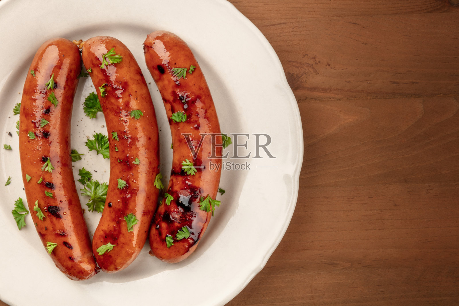 这是一盘油炸香肠的特写照片，从顶部拍摄，背景是黑色的乡村木制品，并有文字的地方照片摄影图片