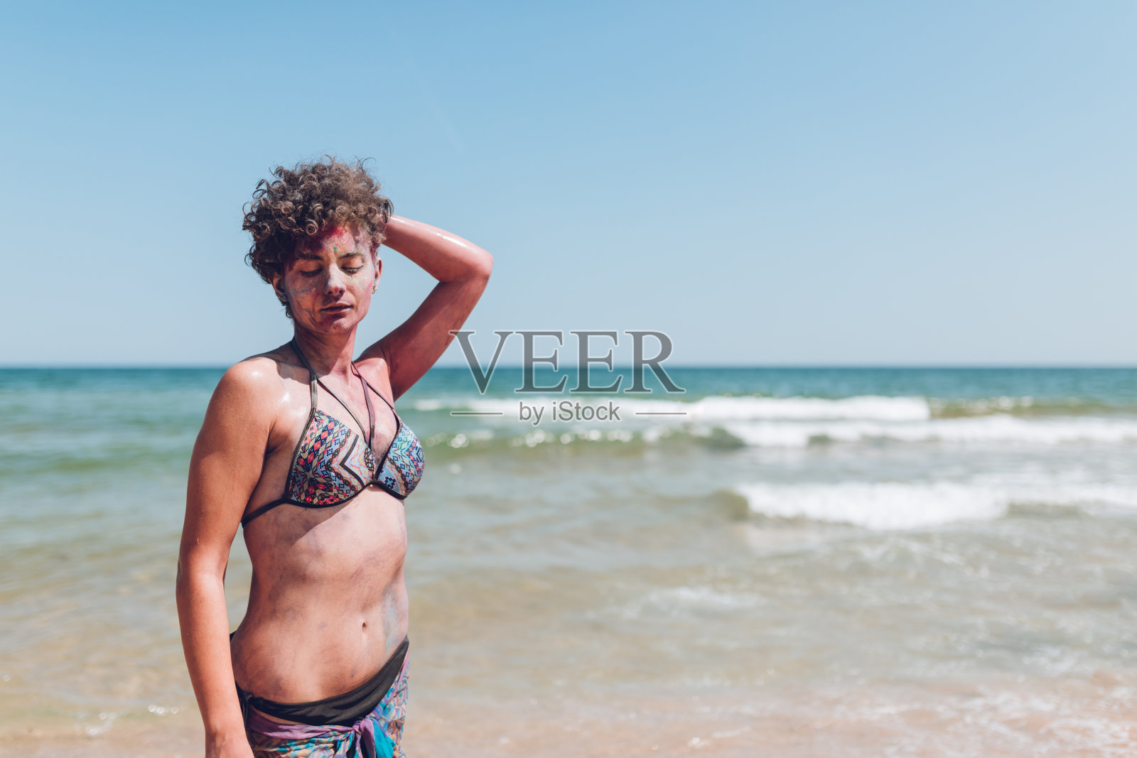 海滩上涂着人体彩绘的女人照片摄影图片