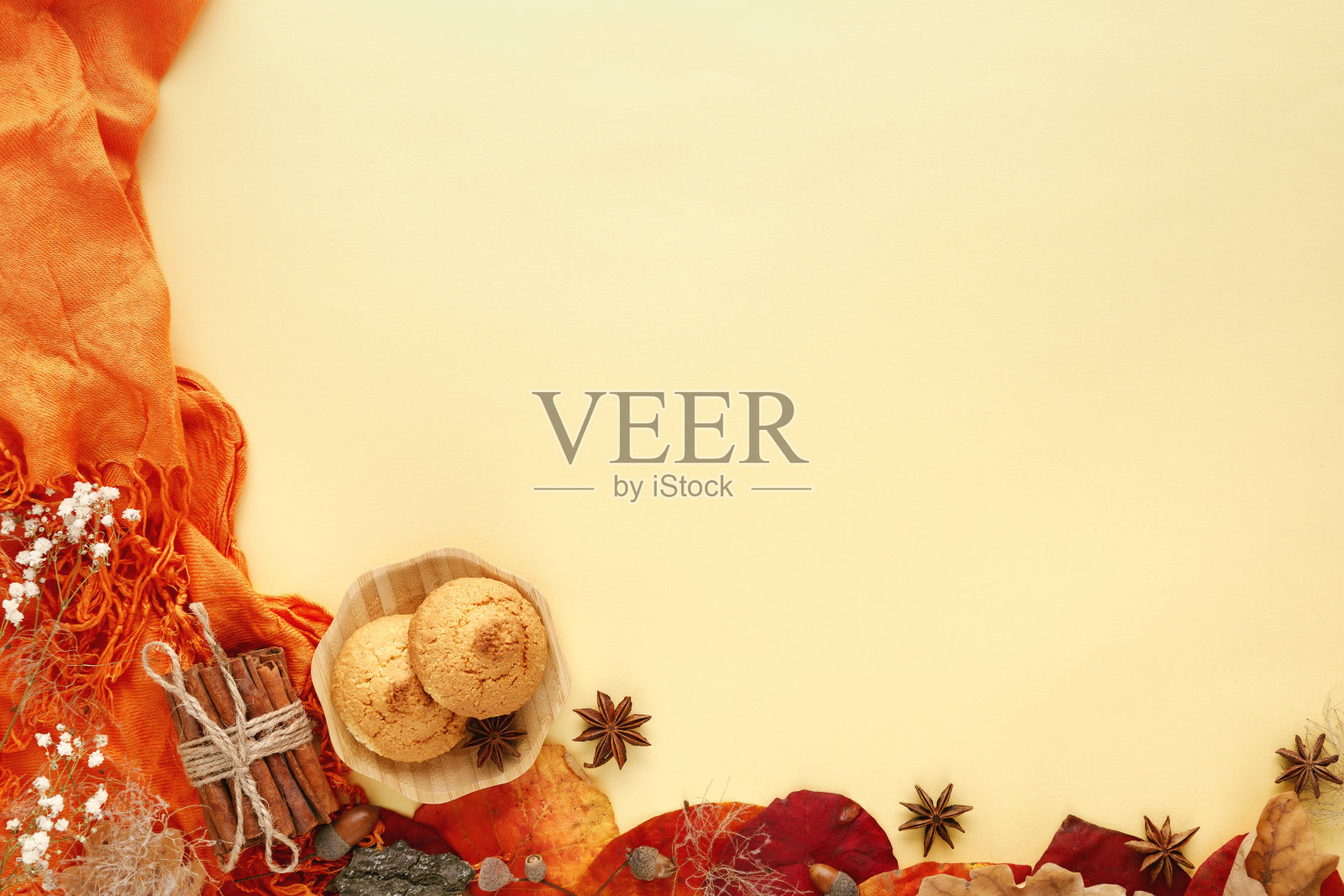 秋天的叶子，饼干和肉桂在黄色的背景照片摄影图片