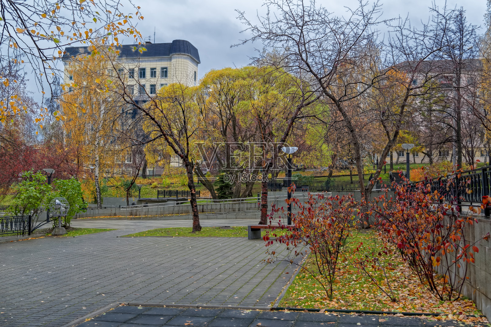 在一个秋雨的日子里，城市池塘的堤岸照片摄影图片