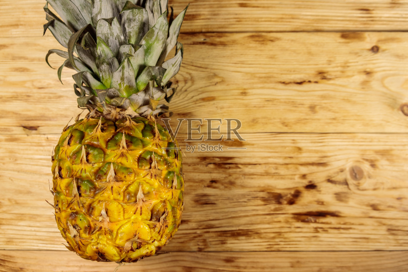 整个菠萝放在木桌上。俯视图，复制空间照片摄影图片