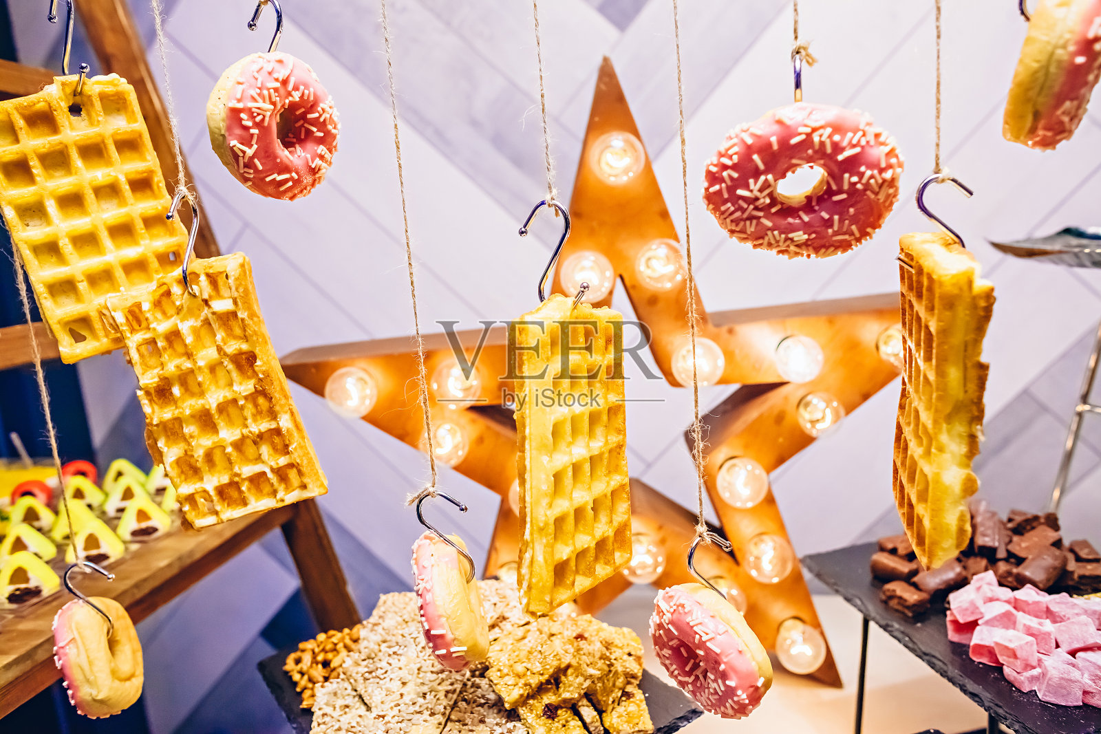 自助餐台上的绳子上挂着华夫饼和甜甜圈照片摄影图片