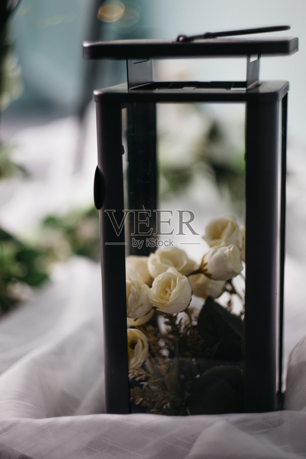 莫斯科，俄罗斯- 2018年06月10日:黑色金属灯，白色玫瑰，蜡烛和花的光背景，家庭装饰，照片摄影图片