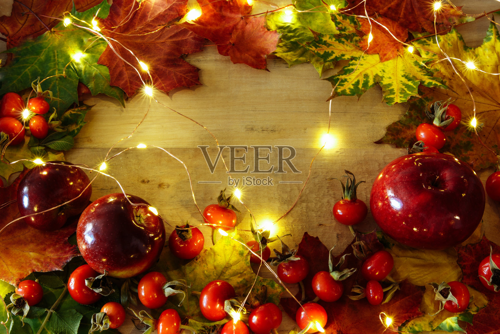 秋天的背景，黄色的叶子与红苹果和玫瑰果照片摄影图片