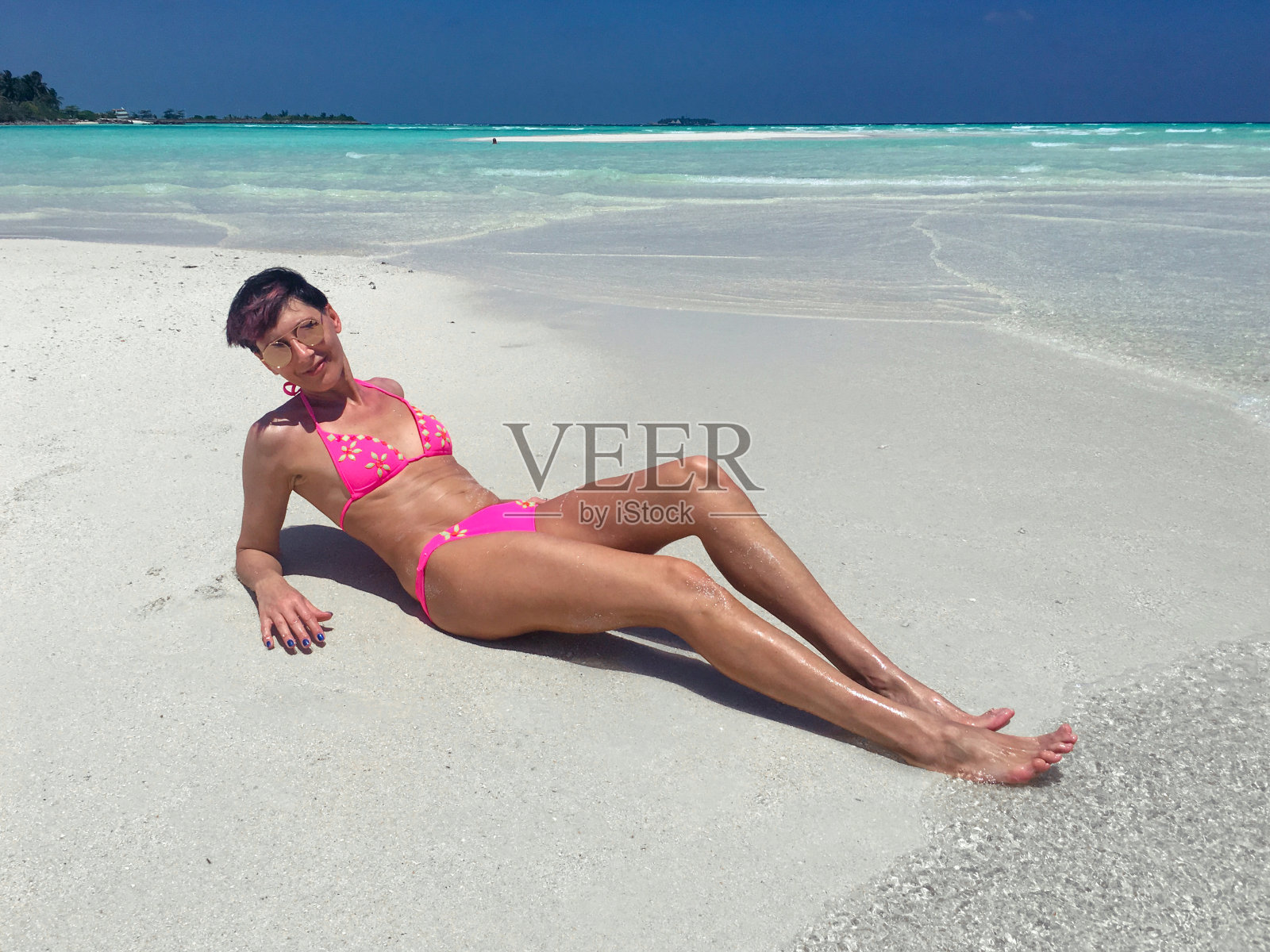 微笑的成年女子在热带岛屿的海滩上放松照片摄影图片